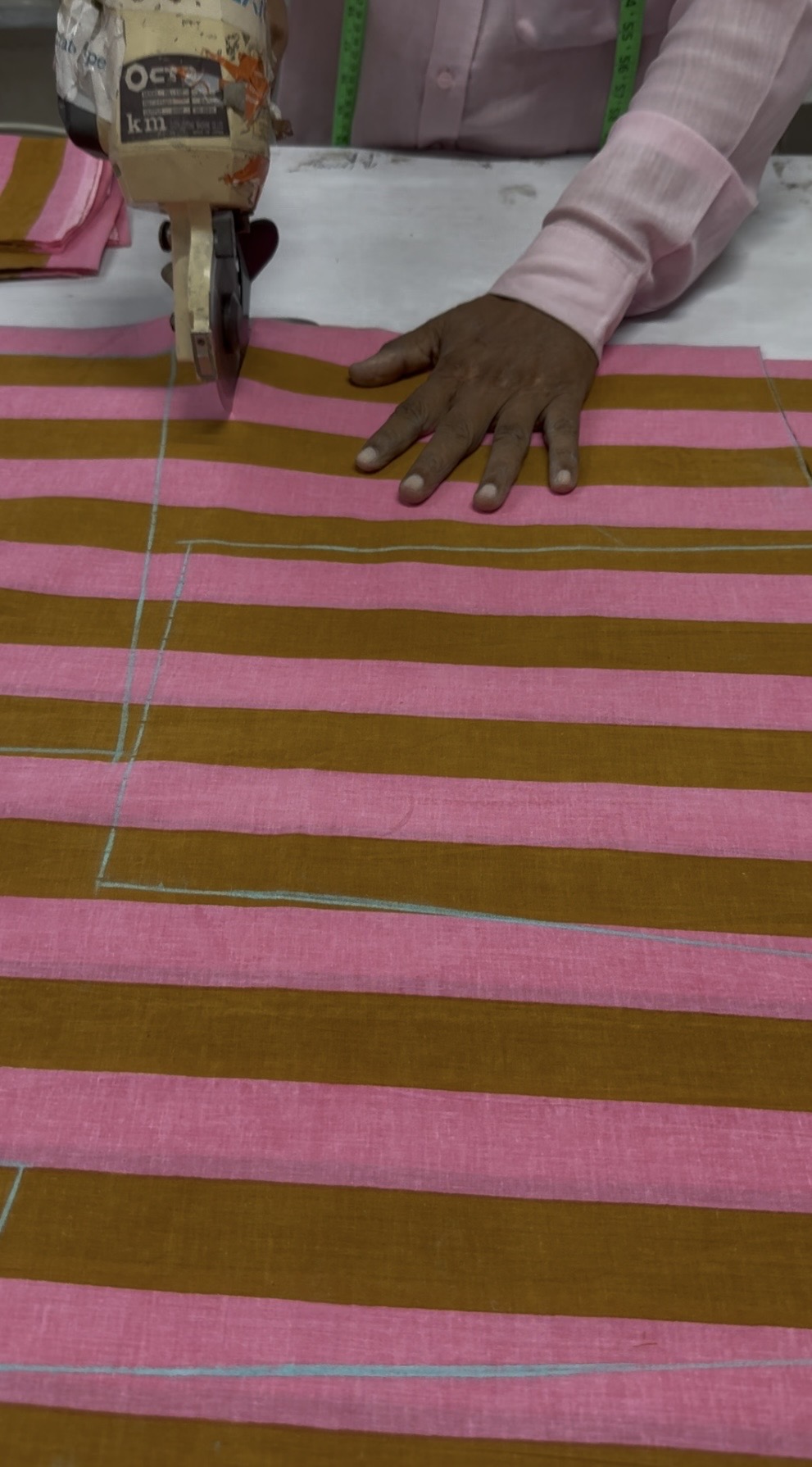 A skilled artisan cutting fabric in our workshop
