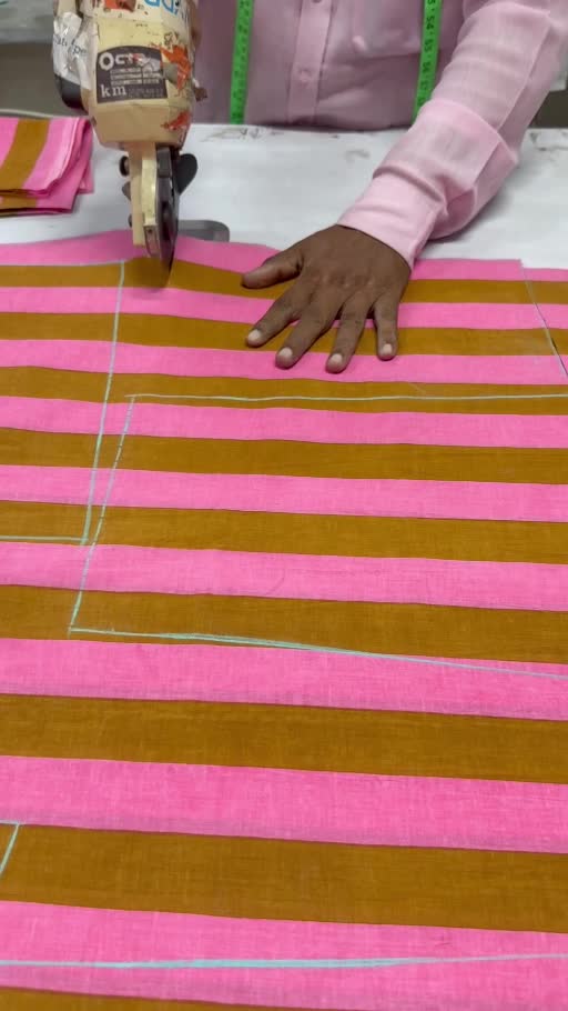 A skilled maker cutting striped fabric