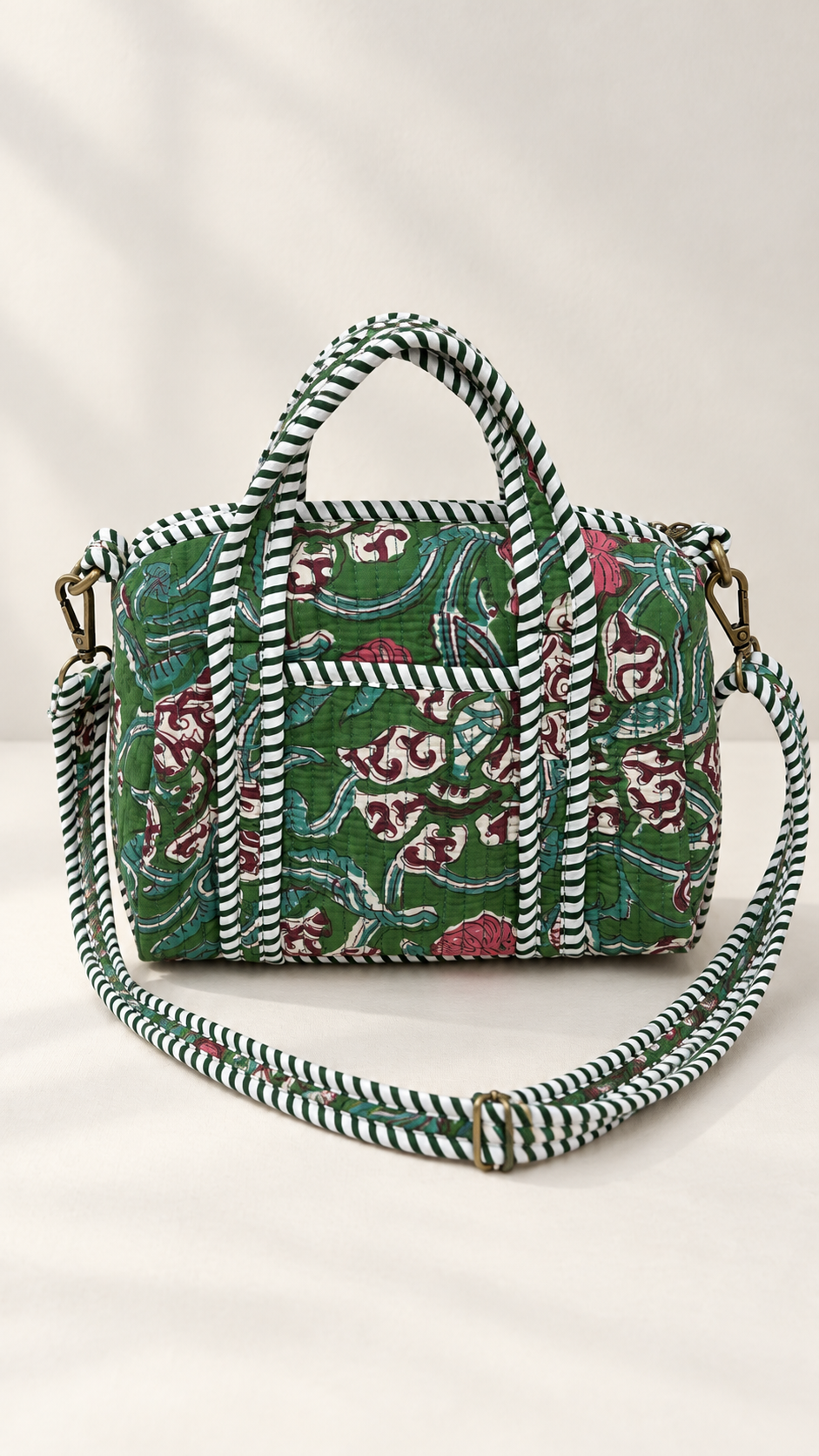 Green printed quilted handbag with striped shoulder strap