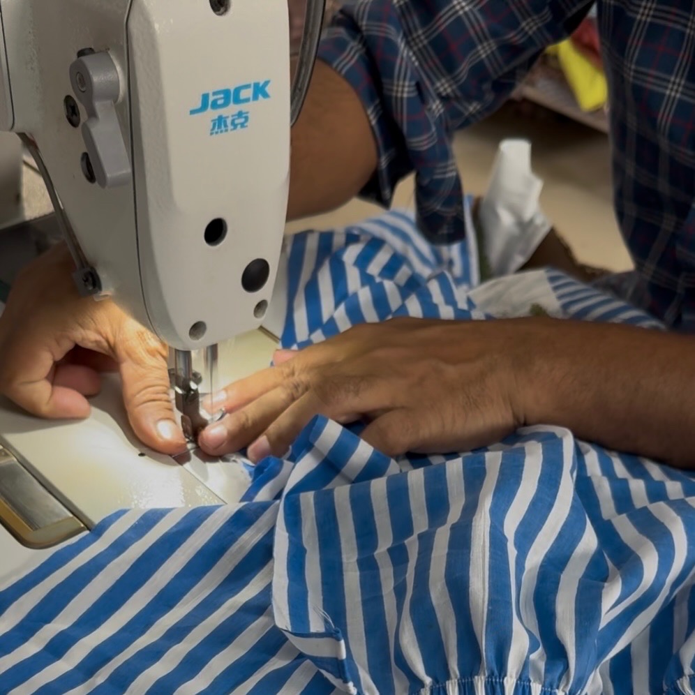 Stitching blue striped fabric in our workshop